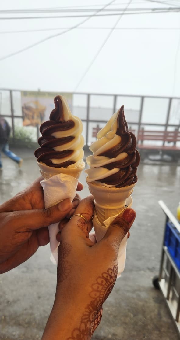 Two chocolate and vanilla ice cream cones held together for a sweet cheers